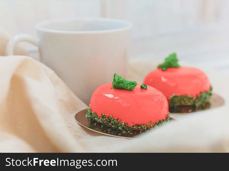 Bright orange mousse cakes and cup of coffee on white wooden tray, breackfast concept