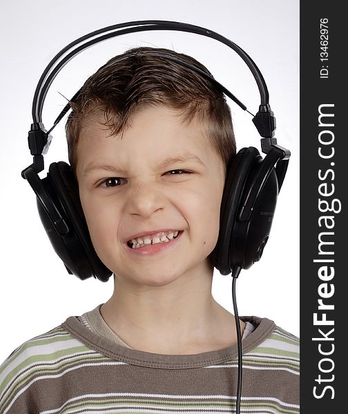 Kid with headset - squinting and listening music. Kid with headset - squinting and listening music.