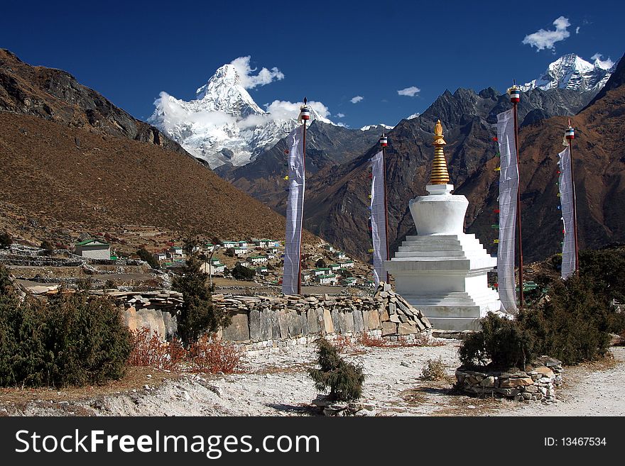 Buddhist temple and preying stones in the village Kumjung on 4200m with the view of Ama Dablam peak. Buddhist temple and preying stones in the village Kumjung on 4200m with the view of Ama Dablam peak