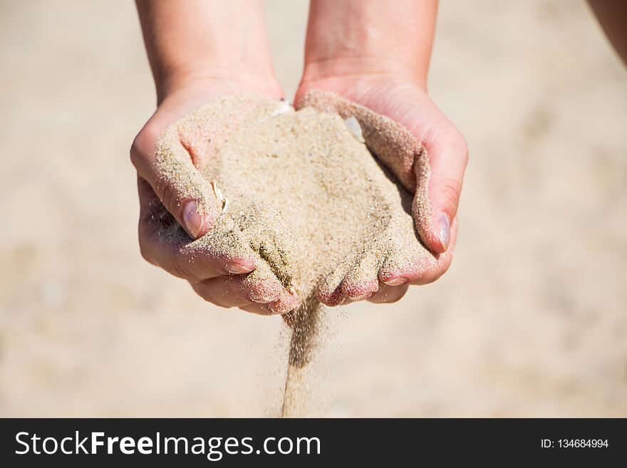 Hand with sand. Hand sand down gently on the beach. Hand with sand. Hand sand down gently on the beach