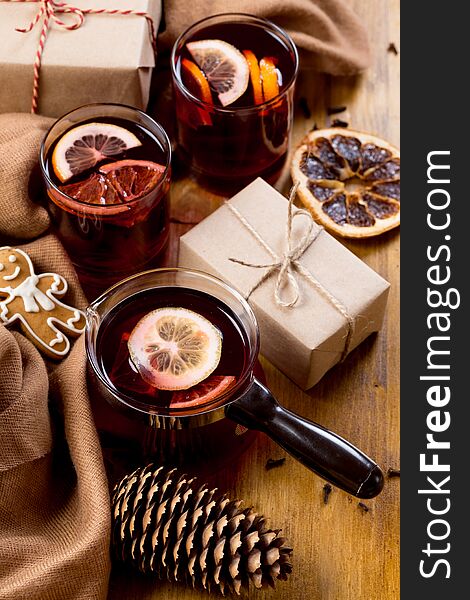 Mulled wine in glass mug with spices. Christmas hot drink on wooden table. Top view.