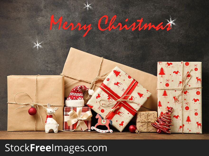 Christmas gifts in craft paper with Christmas decoration on a black background. Caption: `Merry Christmas`