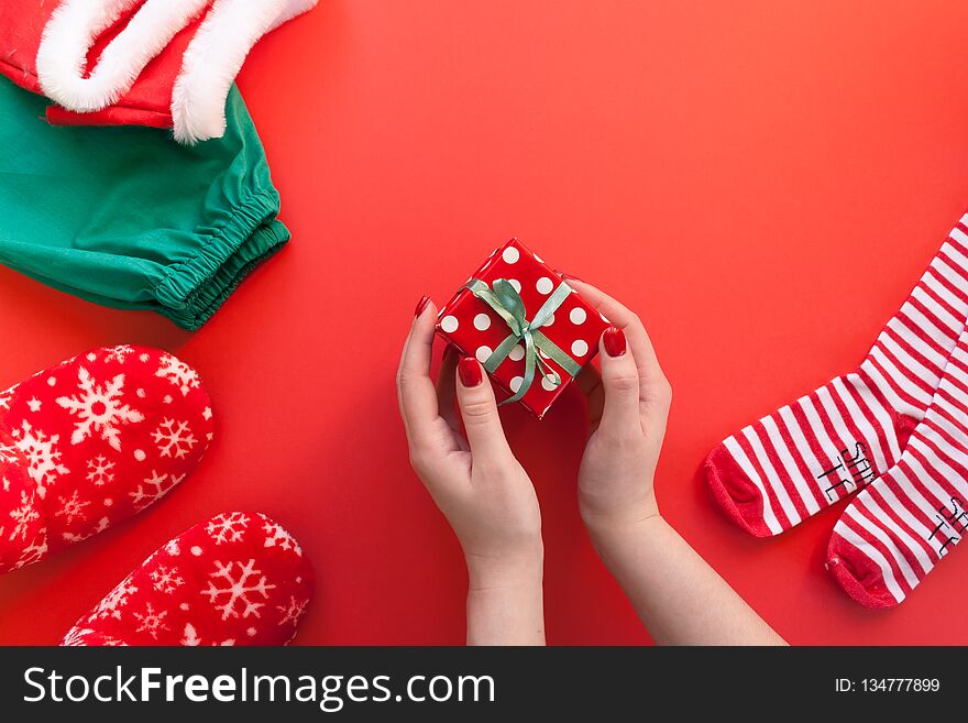 Women`s hands holding a gift on a red background. Women`s hands holding a gift on a red background