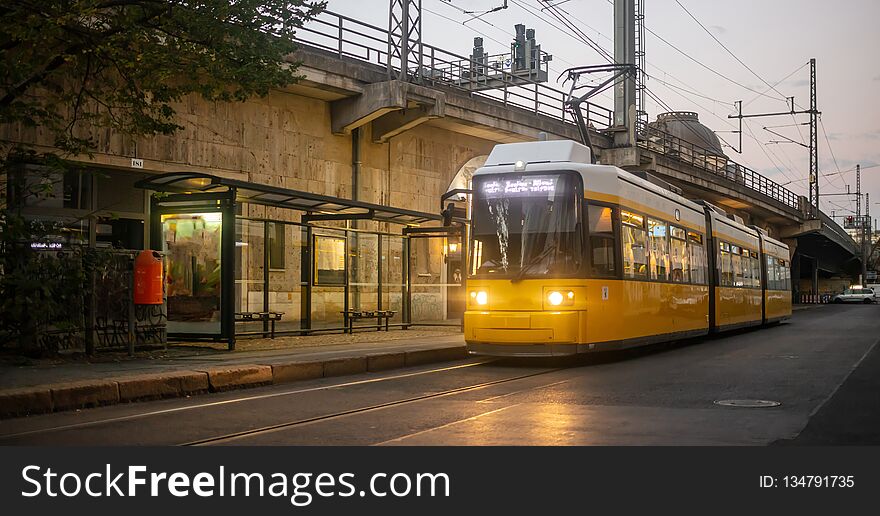 Public transportation concept. Yellow electric tram at Berlin, Germany. Cloudy sky background