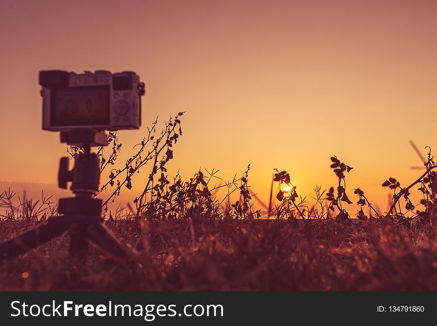 Professional camera on tripod taking picture film video of sunrise over sea surface, Greece. Professional camera on tripod taking picture film video of sunrise over sea surface, Greece