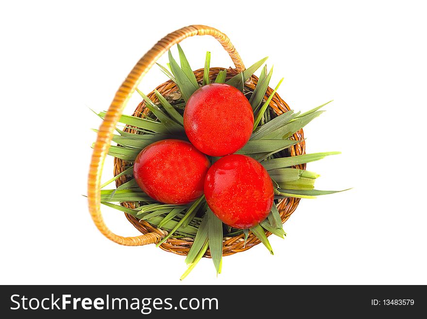 Easter basket with green grass and three red eggs isolated on white background. Easter basket with green grass and three red eggs isolated on white background