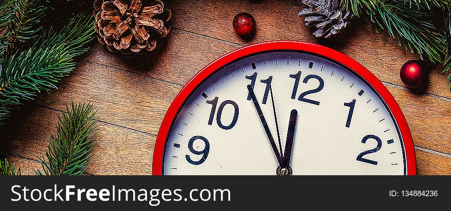Christmas decoration and little alarm clock near pine branch