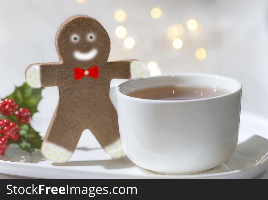 Gingerbreadman cookiee decorated for christmas and a cup of hot coffee for you on a joyful holy day. Xmas flower is on the left side of the plate. Macro photography