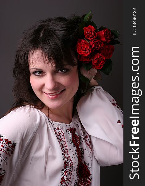 Young smiling girl in national ukrainian blouse with red flowers. Young smiling girl in national ukrainian blouse with red flowers