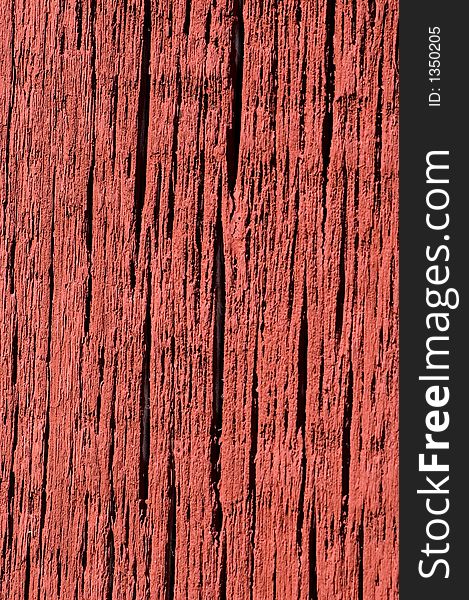 Bright red paint on weathered barn board.