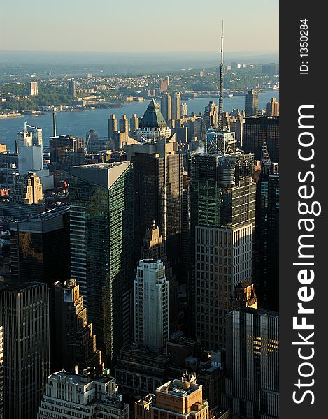 Aerial view of a several urban office buildings.  There is a river in the background.  It is early in the morning.  The scene is lit by a low warm sunlight. Aerial view of a several urban office buildings.  There is a river in the background.  It is early in the morning.  The scene is lit by a low warm sunlight.