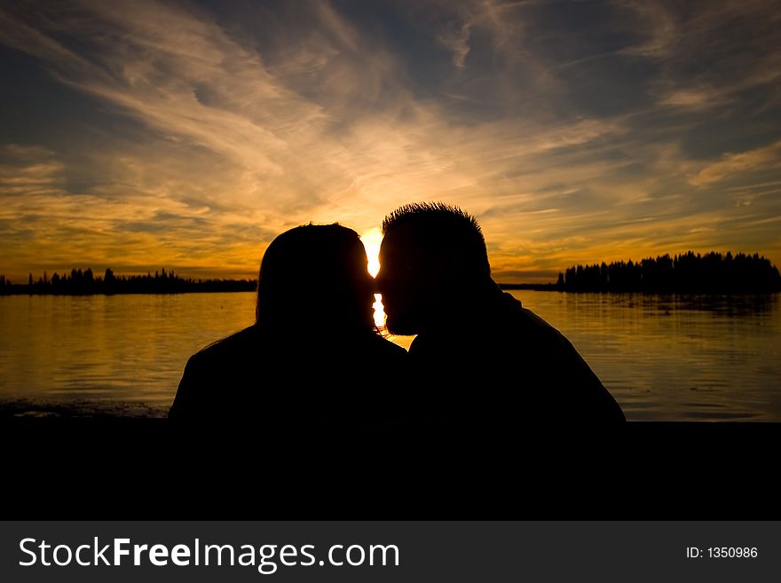 A young couple shares a moment at sunset. A young couple shares a moment at sunset.