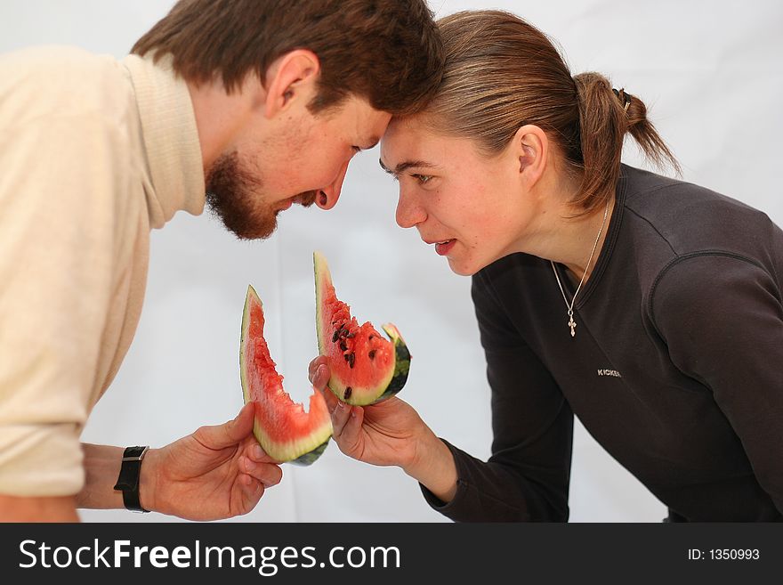 Man and the woman eat a watermelon on white. Man and the woman eat a watermelon on white