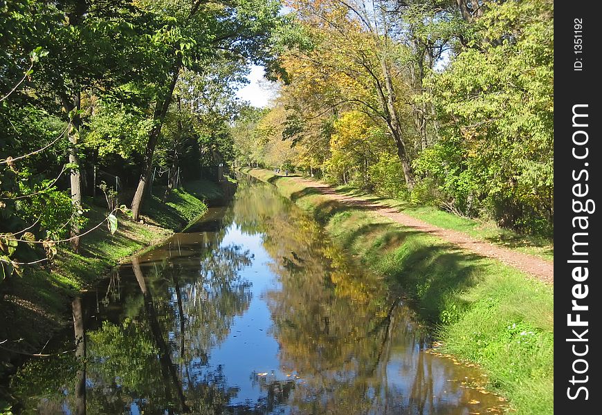 Canal in rural village in autumn with bicycle path. Canal in rural village in autumn with bicycle path.