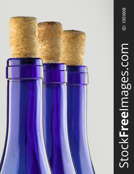 Three blue bottles with corks isolated on white (close up)