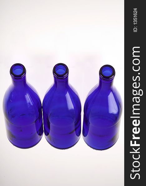 Three empty blue bottles isolated on white (close up)