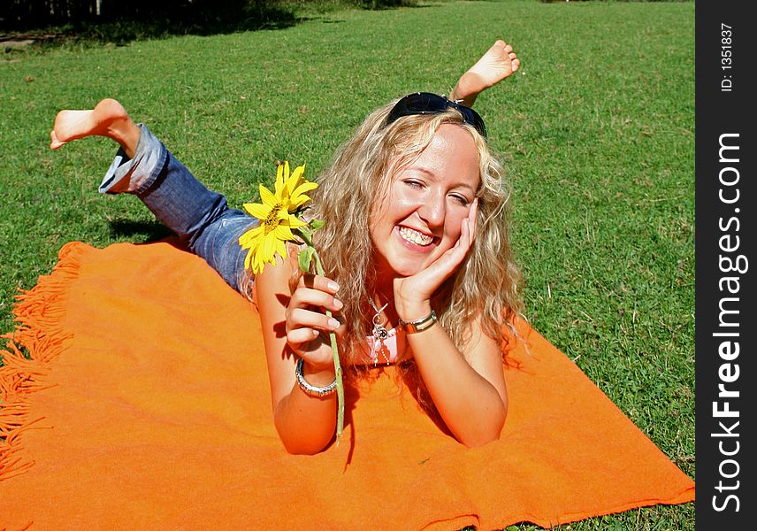 Young fresh teenager lying on blanket with feet up in park. Young fresh teenager lying on blanket with feet up in park