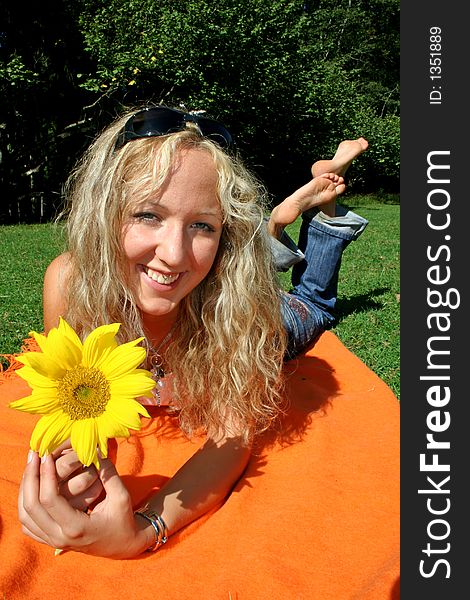 Portrait of beautiful blonde teenager with sunflower in park. Portrait of beautiful blonde teenager with sunflower in park