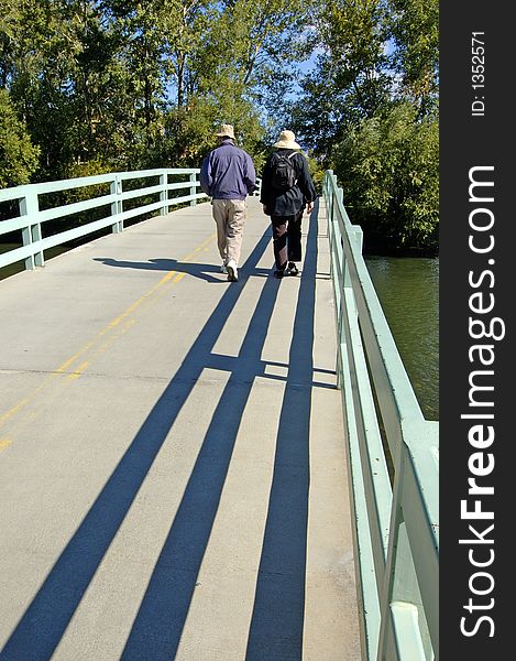 Couple walking across bridge over water