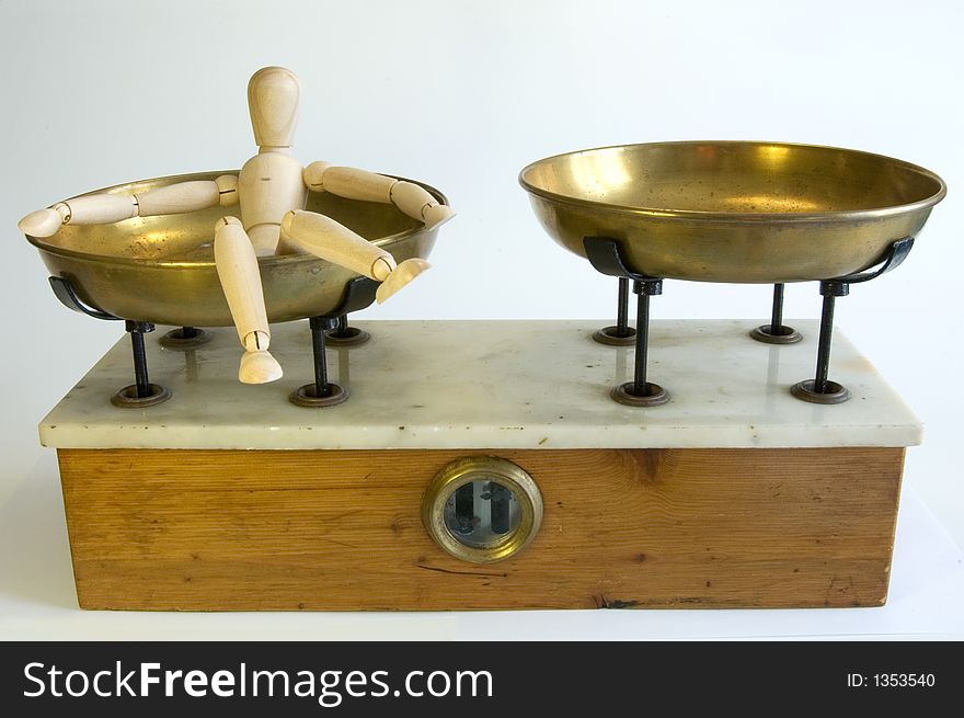 A wooden mannequine laying on a balance plate. A wooden mannequine laying on a balance plate