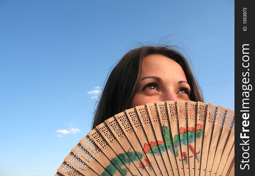 Attractive girl hidden by a fan