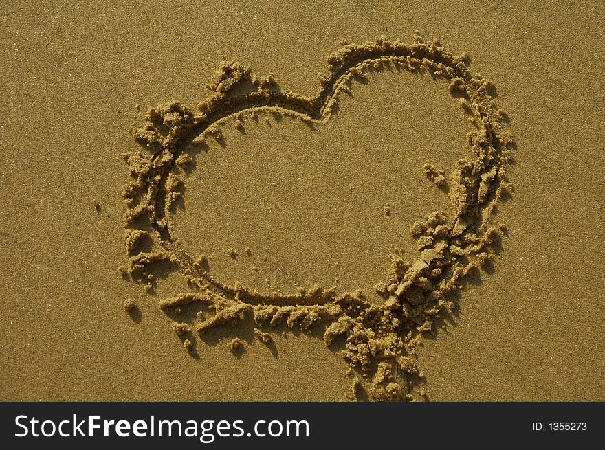 Love heart written in sand