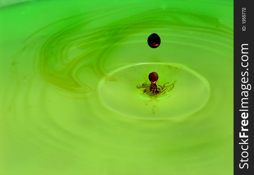 Drop of iodine in a green plastic water bowl. Drop of iodine in a green plastic water bowl