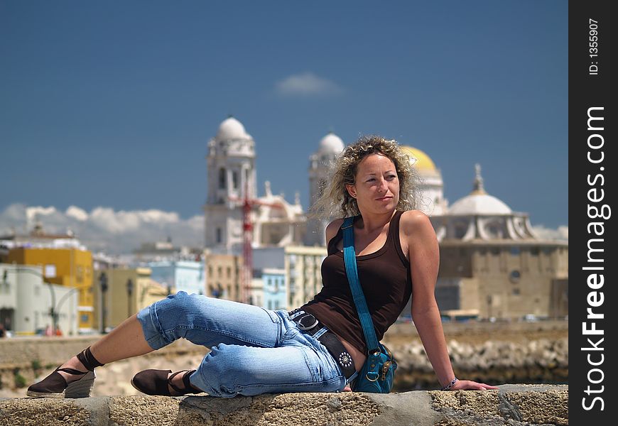 Beautiful girl laying. The Cathedral of Cadiz in the background, Spain