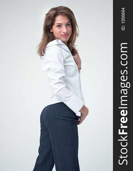 Portrait of a beautiful young girl wearing a casual white shirt looking over her back. Portrait of a beautiful young girl wearing a casual white shirt looking over her back