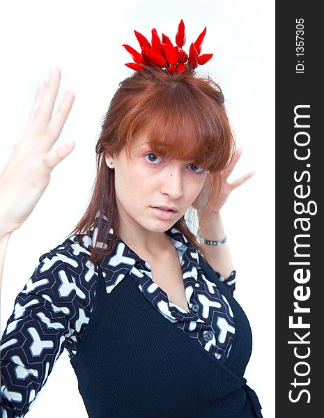 Portrait of a beautiful young girl holding a bunch of red chilli peppers over her head and looking at them; white background. Portrait of a beautiful young girl holding a bunch of red chilli peppers over her head and looking at them; white background