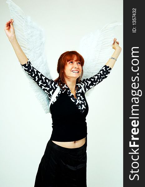 Beautiful girl with angel wings looking up with hands raised. Beautiful girl with angel wings looking up with hands raised