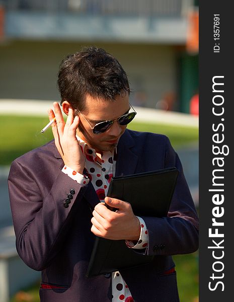 Portrait of a handsome, young agent talking at a hidden mobile device. Portrait of a handsome, young agent talking at a hidden mobile device