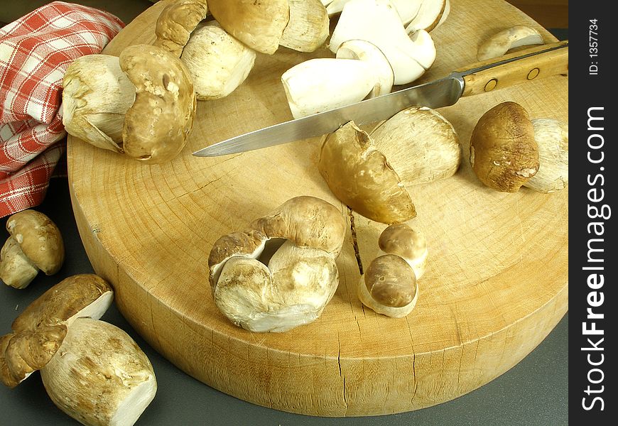 A Selection Of Wild Mushrooms On A Round Cutting Board