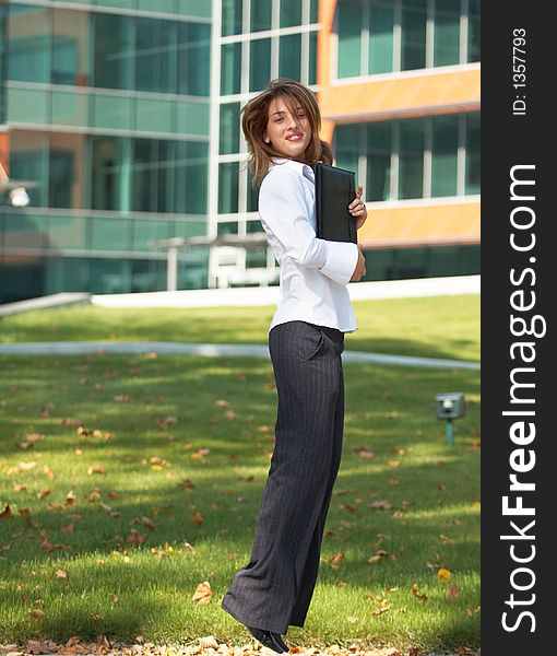 Portrait of a beautiful young girl with casual clothes holding an agenda in her hands, jumping and looking happy. Portrait of a beautiful young girl with casual clothes holding an agenda in her hands, jumping and looking happy