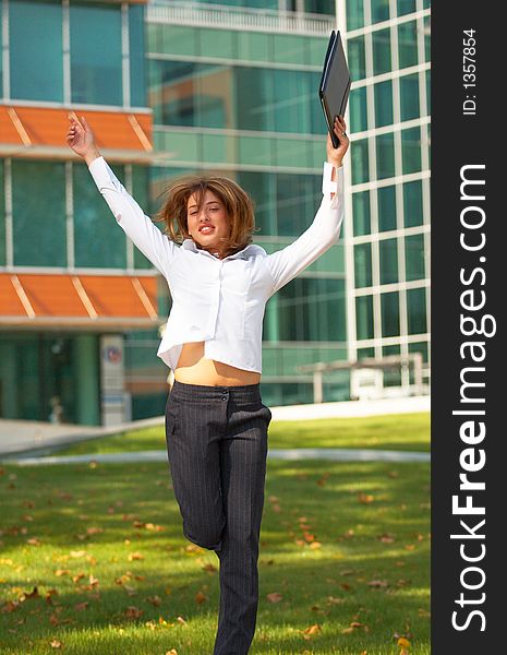 Portrait of a beautiful young girl with casual clothes holding an agenda in her hands, jumping and looking happy. Portrait of a beautiful young girl with casual clothes holding an agenda in her hands, jumping and looking happy