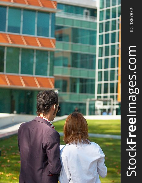 Young boy and girl checking some papers in front of an office building; business couple analising some documents. Young boy and girl checking some papers in front of an office building; business couple analising some documents