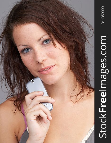 Teenage girl holding a phone and looking into the cam- junges M䤣hen h䬴 ein Telefon und schaut in die Kamera. Teenage girl holding a phone and looking into the cam- junges M䤣hen h䬴 ein Telefon und schaut in die Kamera