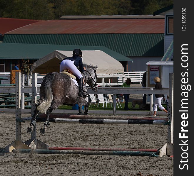 Horse and rider taking jump in local competition. Horse and rider taking jump in local competition