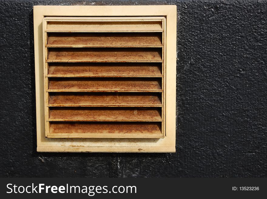 A white ventilation hole in a black wall