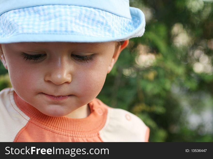 Little thinking boy with blue cap