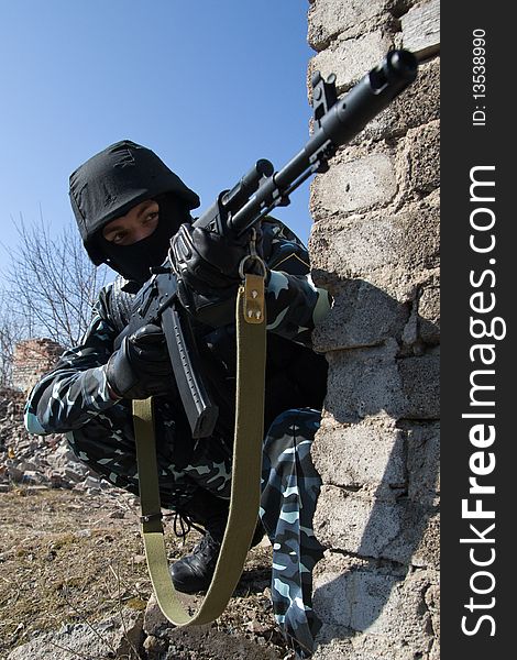 Soldier with automatic rifle in covered postion