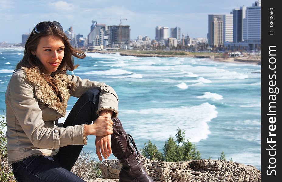 Beautiful young girl on the background of the city and sea. Beautiful young girl on the background of the city and sea