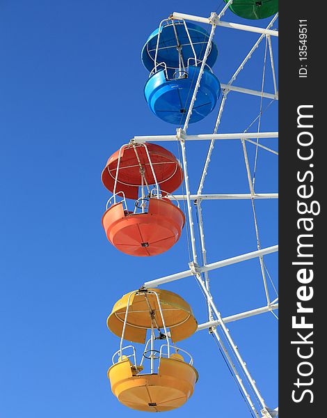 Blue, red, green and yellow carriages of Ferris wheel