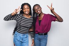 Portrait Of A Two African Girlfriends Showing Two Fingers Sign On Gray Background Stock Photos