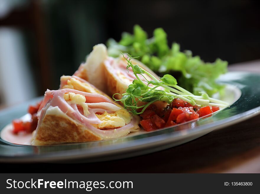 Breakfast burrito ham and eggs with salad vintage style on a dish