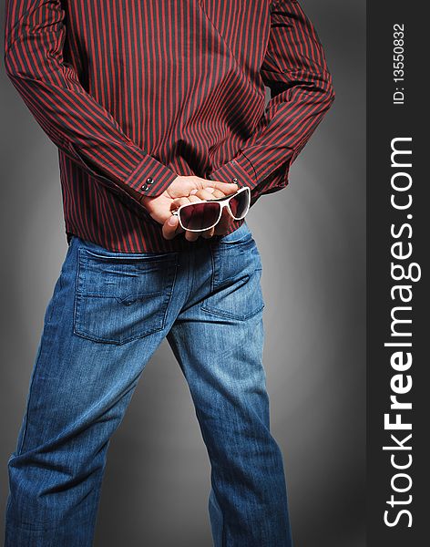 Beautiful blue jeans and red shirt wearing a model with glasses isolated on a gray background.