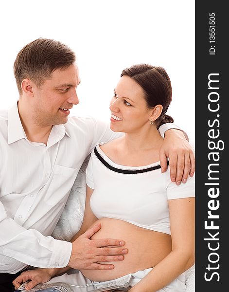 Man with his pregnant wife were sitting on a white background. Man with his pregnant wife were sitting on a white background