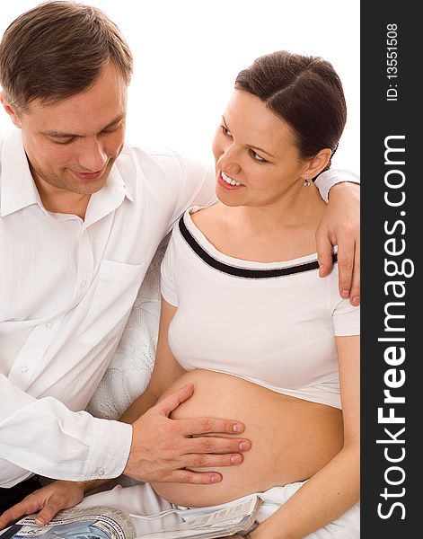 Man with his pregnant wife were sitting on a white background