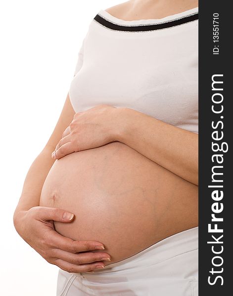 Pregnant woman holding her hands on stomach on a white background. Pregnant woman holding her hands on stomach on a white background