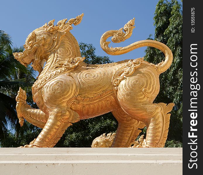 Golden lion, buddhist figure and symbol on base of stone
